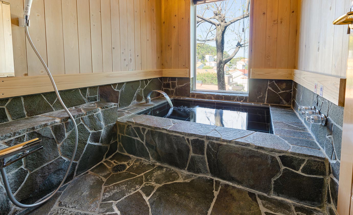 伊豆石と桧貼りの浴室